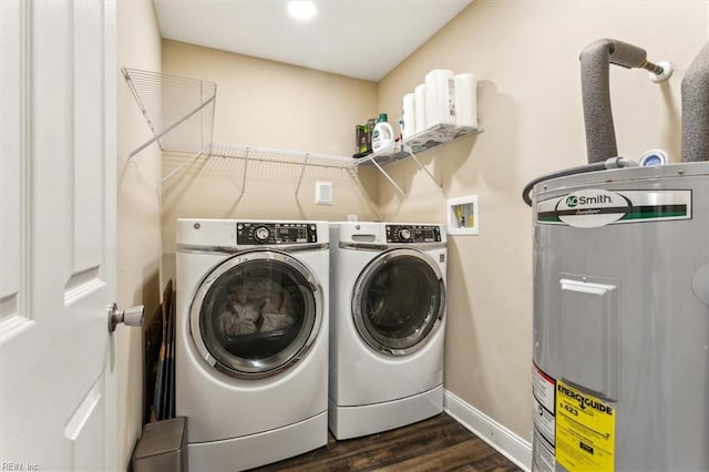 washroom featuring laundry area, dark wood-style flooring, baseboards, water heater, and washer and dryer