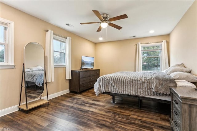 bedroom featuring dark wood-style floors, multiple windows, visible vents, and baseboards