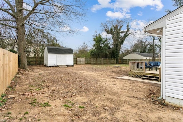 view of yard featuring a fenced backyard, an outdoor structure, a wooden deck, and a shed