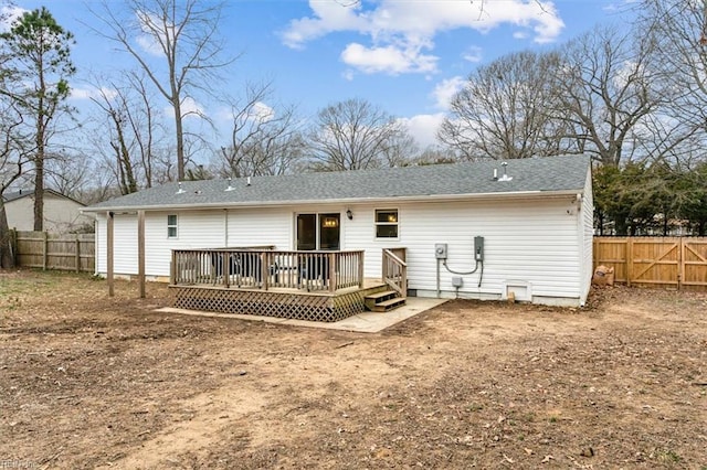 back of property with fence and a wooden deck