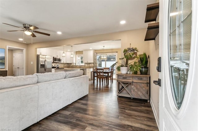 living area with ceiling fan, dark wood-type flooring, and recessed lighting