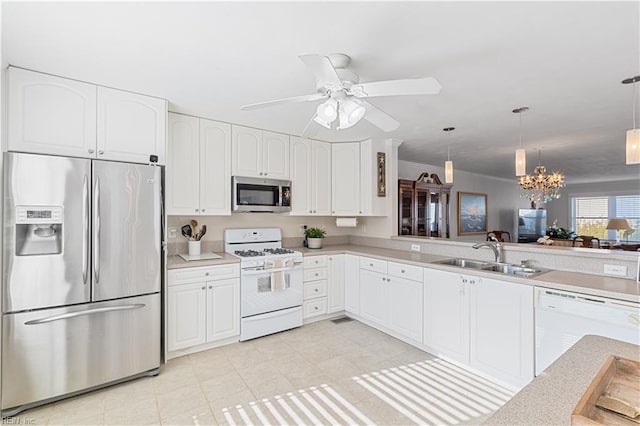 kitchen featuring a sink, white cabinets, light countertops, appliances with stainless steel finishes, and hanging light fixtures