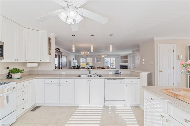 kitchen with white appliances, ornamental molding, open floor plan, light countertops, and a sink