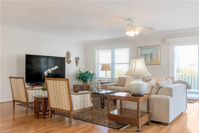 living room featuring crown molding, baseboards, ceiling fan, and wood finished floors