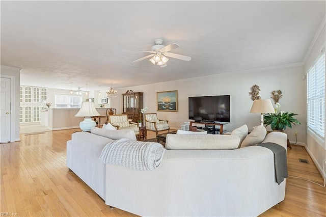 living area with ceiling fan with notable chandelier, visible vents, light wood-style flooring, and baseboards