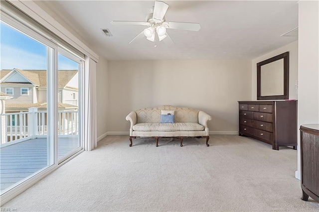 sitting room with baseboards, visible vents, ceiling fan, and light colored carpet