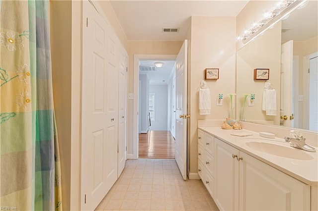 bathroom featuring tile patterned flooring, visible vents, baseboards, and vanity