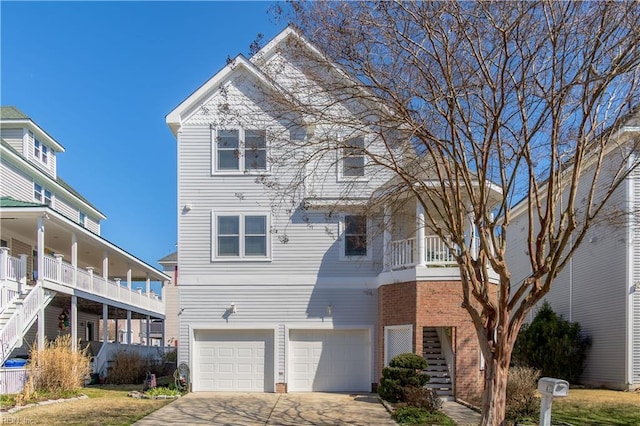 view of front of home featuring a garage, stairs, concrete driveway, and brick siding