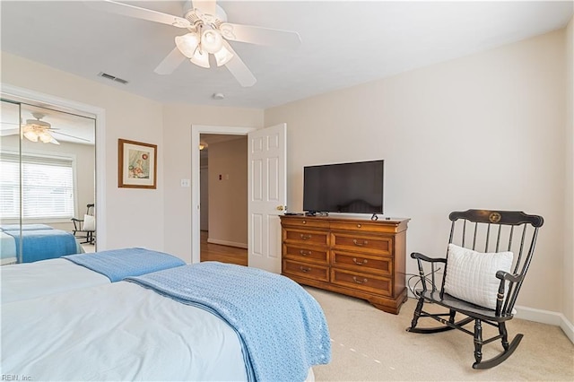 carpeted bedroom with a ceiling fan, a closet, visible vents, and baseboards