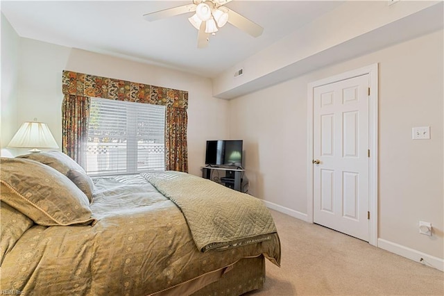 bedroom featuring light colored carpet, ceiling fan, visible vents, and baseboards