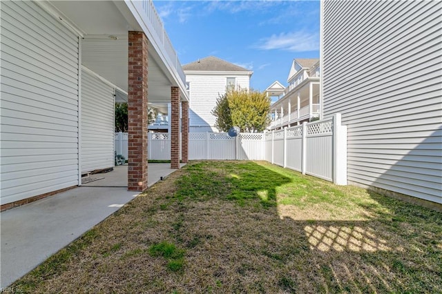 view of yard with a residential view, a fenced backyard, and a patio