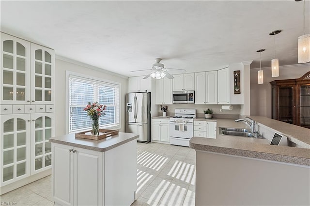 kitchen with crown molding, light tile patterned floors, stainless steel appliances, glass insert cabinets, and a sink