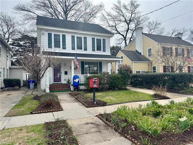 view of front of property featuring covered porch and a front yard