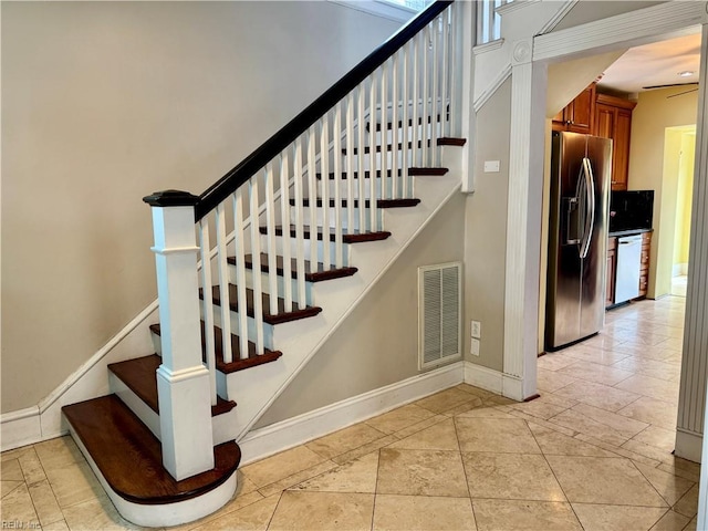 stairway with tile patterned floors, visible vents, and baseboards