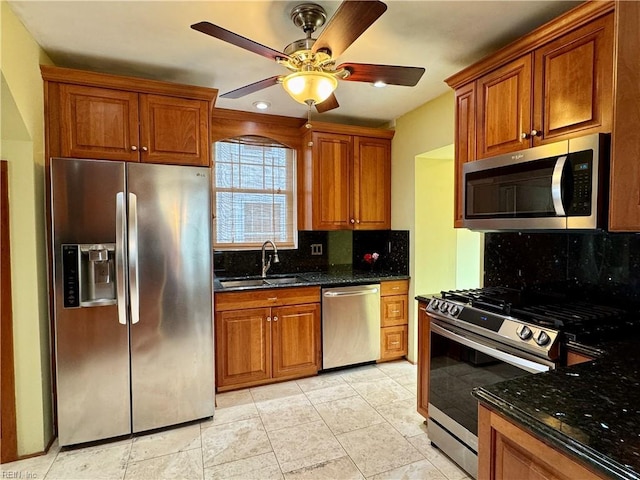 kitchen featuring appliances with stainless steel finishes, a sink, and brown cabinets