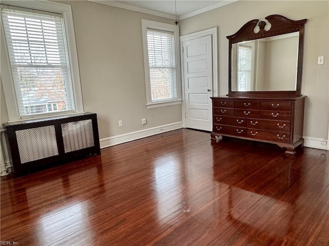 unfurnished bedroom with ornamental molding, radiator, baseboards, and dark wood-style floors