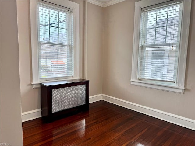 empty room featuring baseboards, dark wood-style flooring, and a healthy amount of sunlight