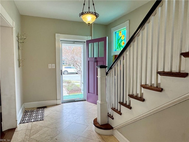 entryway with stairs, tile patterned floors, and baseboards