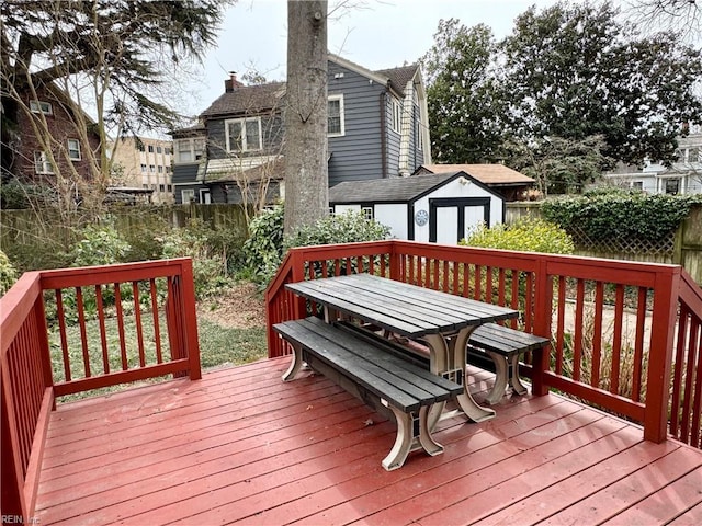 deck with an outdoor structure, fence, and a shed