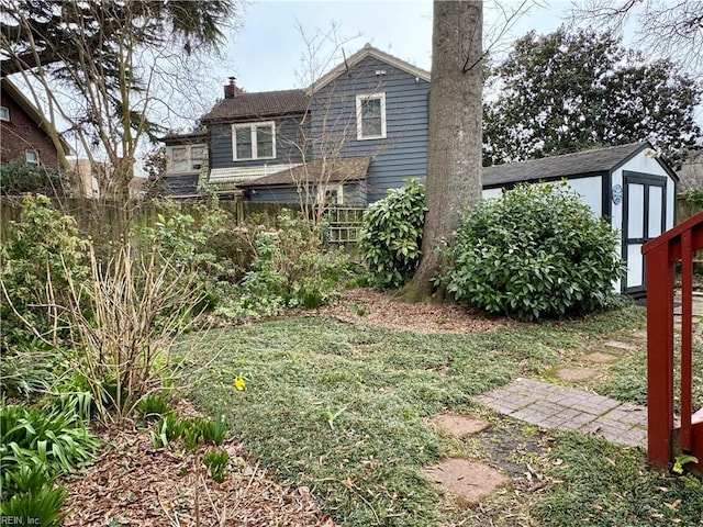 rear view of property with a storage shed, a chimney, and an outbuilding