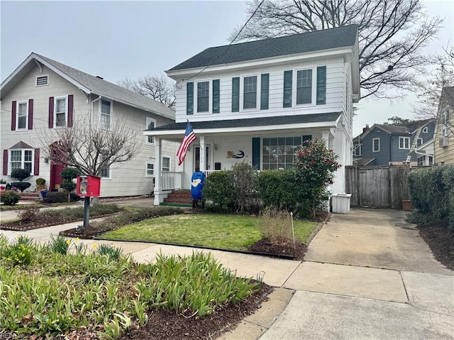 view of front of property with a front yard, covered porch, and fence