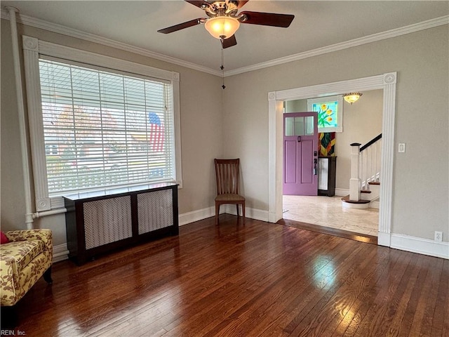 living area featuring wood-type flooring, stairway, baseboards, and ornamental molding