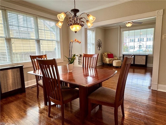 dining room featuring ornamental molding, ceiling fan with notable chandelier, baseboards, and dark wood-style floors