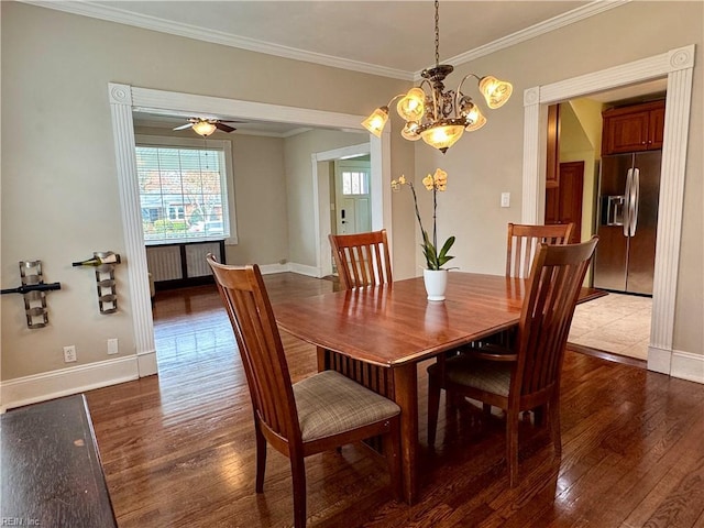 dining room with ornamental molding, wood finished floors, and baseboards