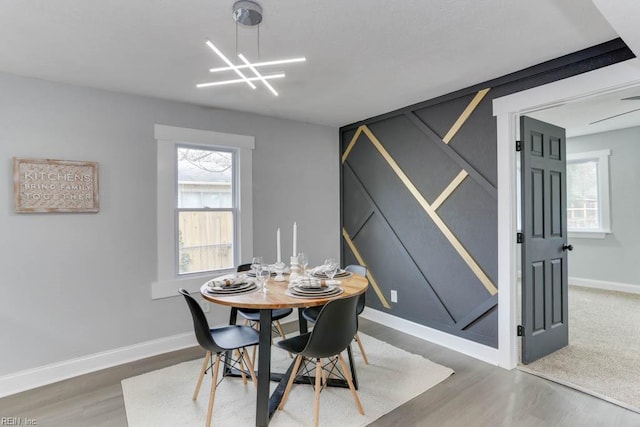 dining room featuring a notable chandelier, baseboards, and wood finished floors