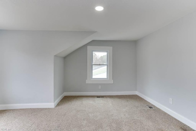 bonus room featuring lofted ceiling, carpet, and baseboards