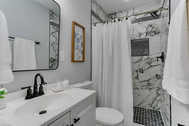 bathroom featuring a stall shower, a textured wall, vanity, and toilet