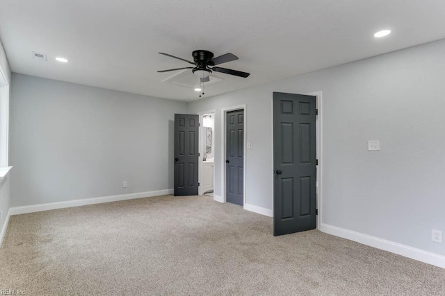 unfurnished bedroom featuring baseboards, visible vents, light colored carpet, ensuite bathroom, and recessed lighting