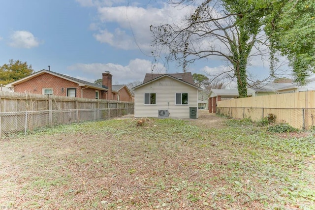 rear view of house with ac unit and a fenced backyard