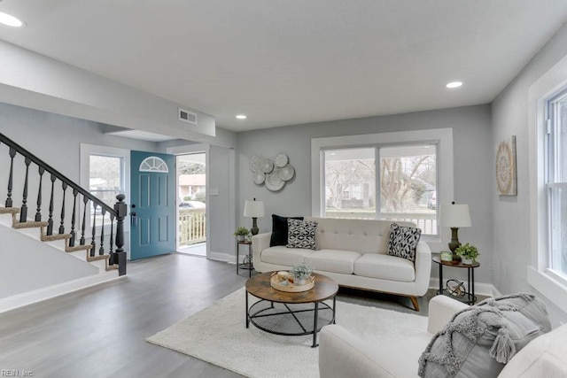 living area with baseboards, visible vents, wood finished floors, stairs, and recessed lighting