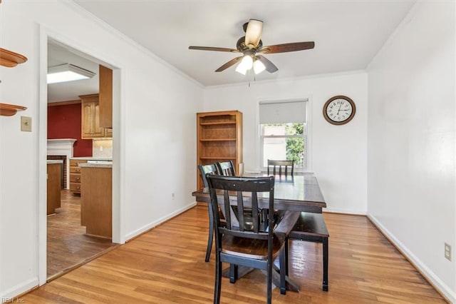 dining room featuring ornamental molding, light wood-type flooring, and baseboards