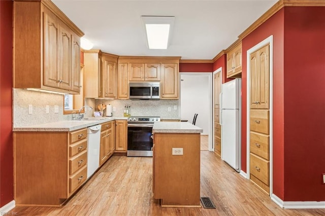 kitchen featuring stainless steel appliances, light countertops, visible vents, a sink, and light wood-type flooring