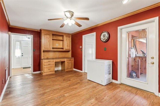 kitchen featuring a ceiling fan, light wood-style floors, built in study area, ornamental molding, and fridge