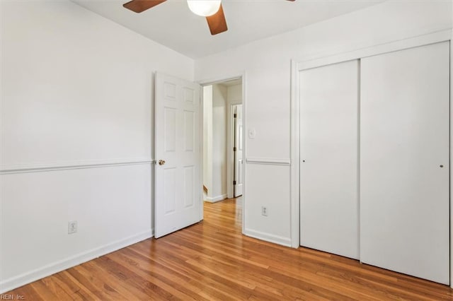 unfurnished bedroom featuring light wood finished floors, ceiling fan, baseboards, and a closet