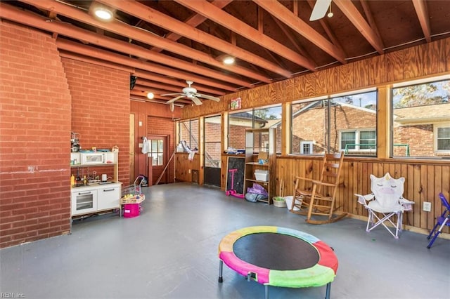 unfurnished sunroom with ceiling fan and vaulted ceiling