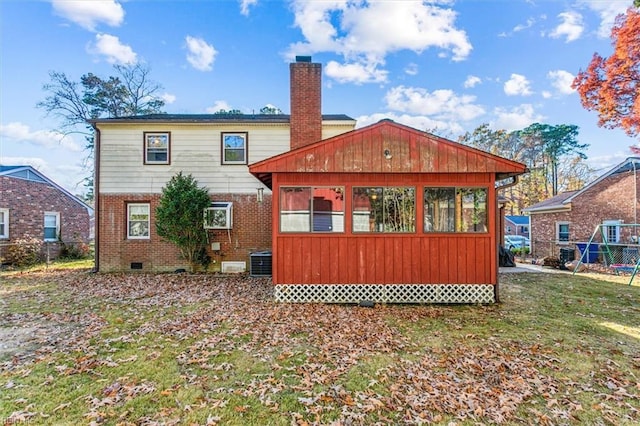 back of house with brick siding, a chimney, central AC unit, a sunroom, and crawl space