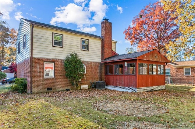 rear view of house with a sunroom, brick siding, a chimney, and crawl space