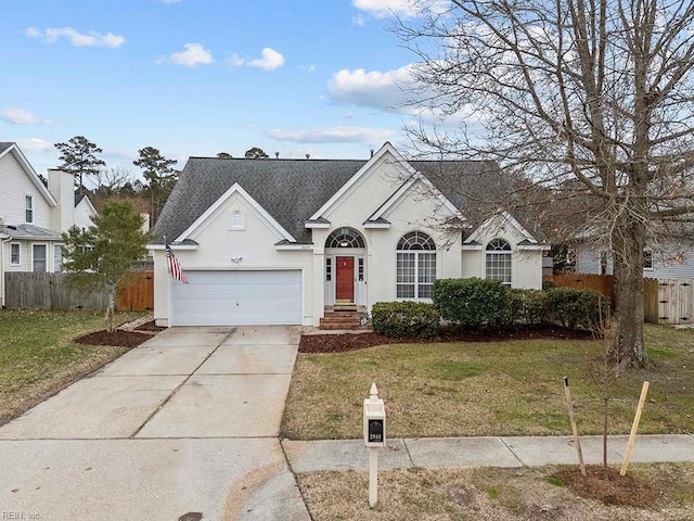 view of front of home with stucco siding, a shingled roof, fence, driveway, and a front lawn