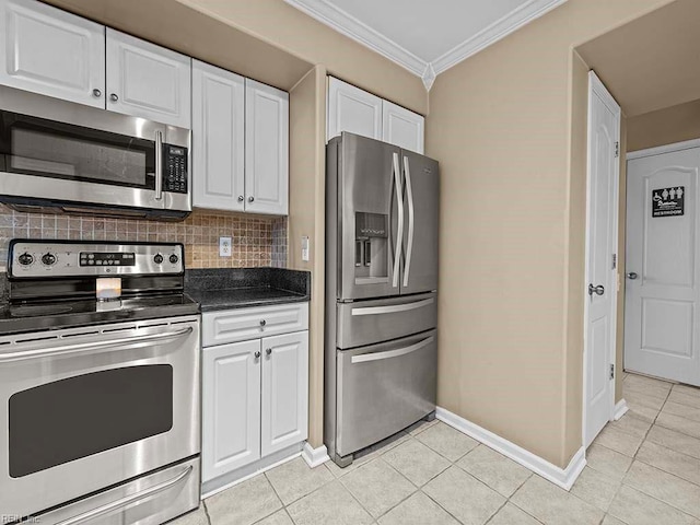 kitchen featuring light tile patterned floors, decorative backsplash, appliances with stainless steel finishes, ornamental molding, and white cabinetry