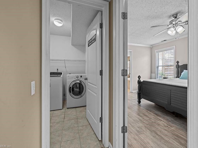 laundry room featuring a textured ceiling, ceiling fan, laundry area, washer and dryer, and crown molding