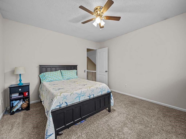 carpeted bedroom with a textured ceiling, ceiling fan, and baseboards