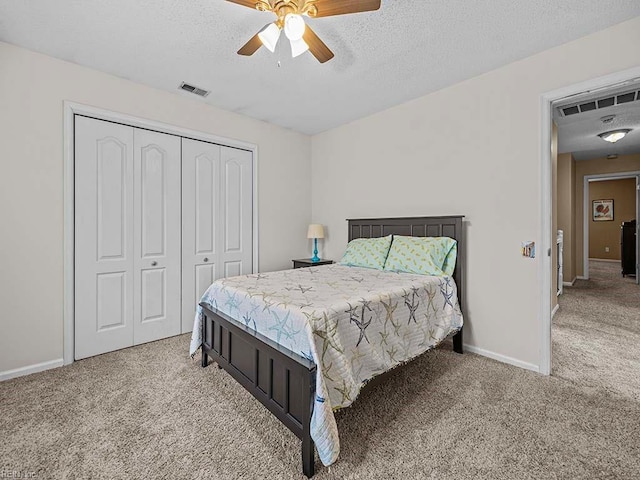 carpeted bedroom featuring baseboards, a textured ceiling, visible vents, and a closet