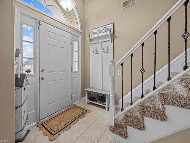 foyer with stairs, light tile patterned floors, and visible vents