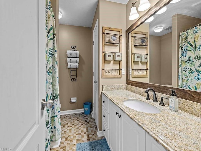 bathroom featuring baseboards and vanity