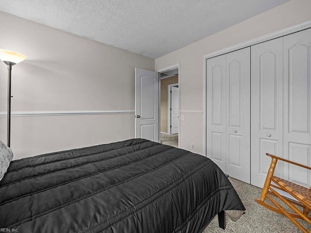 bedroom featuring a closet, carpet flooring, and a textured ceiling