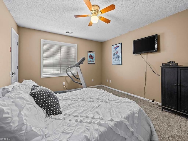 bedroom featuring a ceiling fan, a textured ceiling, baseboards, and carpet flooring